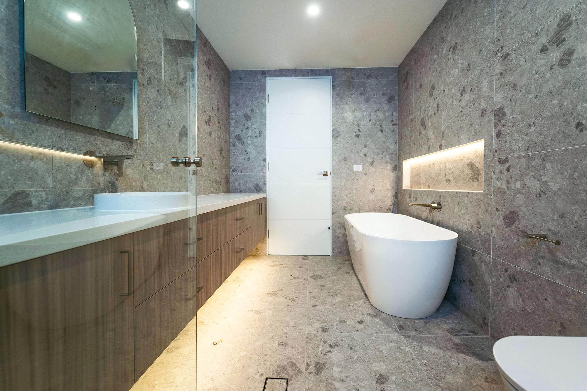 Extended light walnut custom bathroom vanity with generous storage