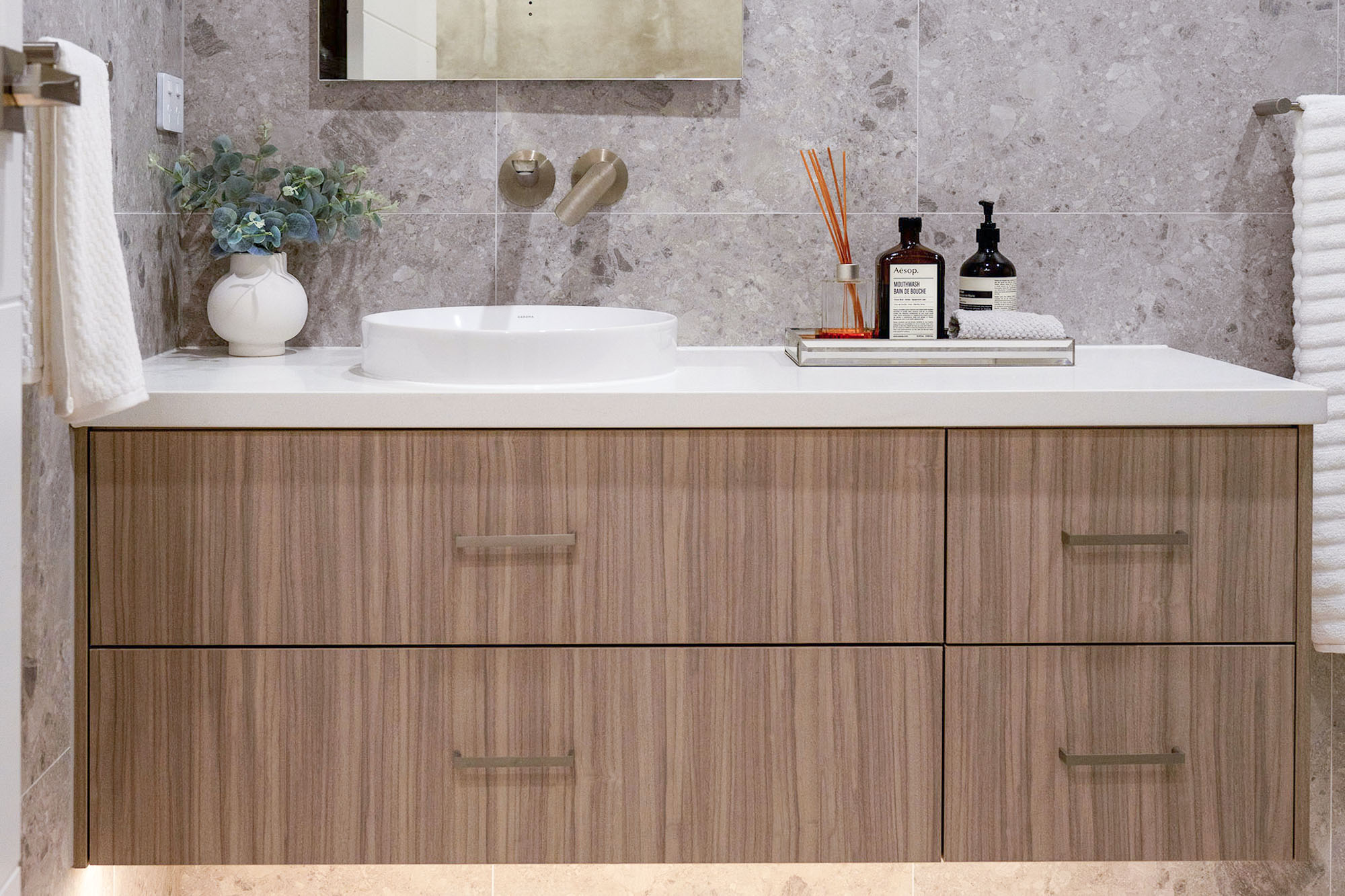 Light walnut bathroom vanity with top mount basin and custom cabinetry