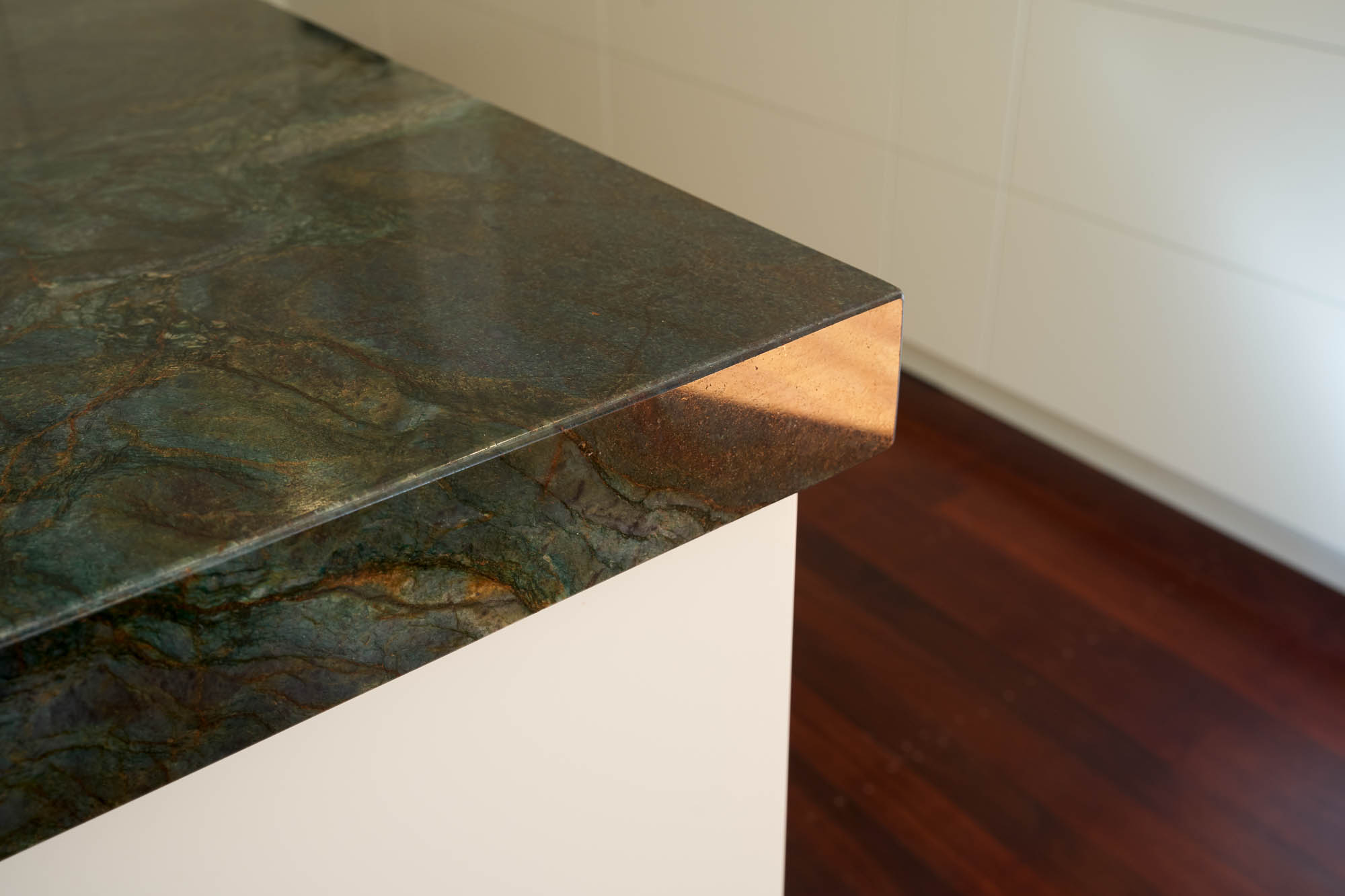 Flat white custom kitchen with green stone 40mm benchtop by Renolux