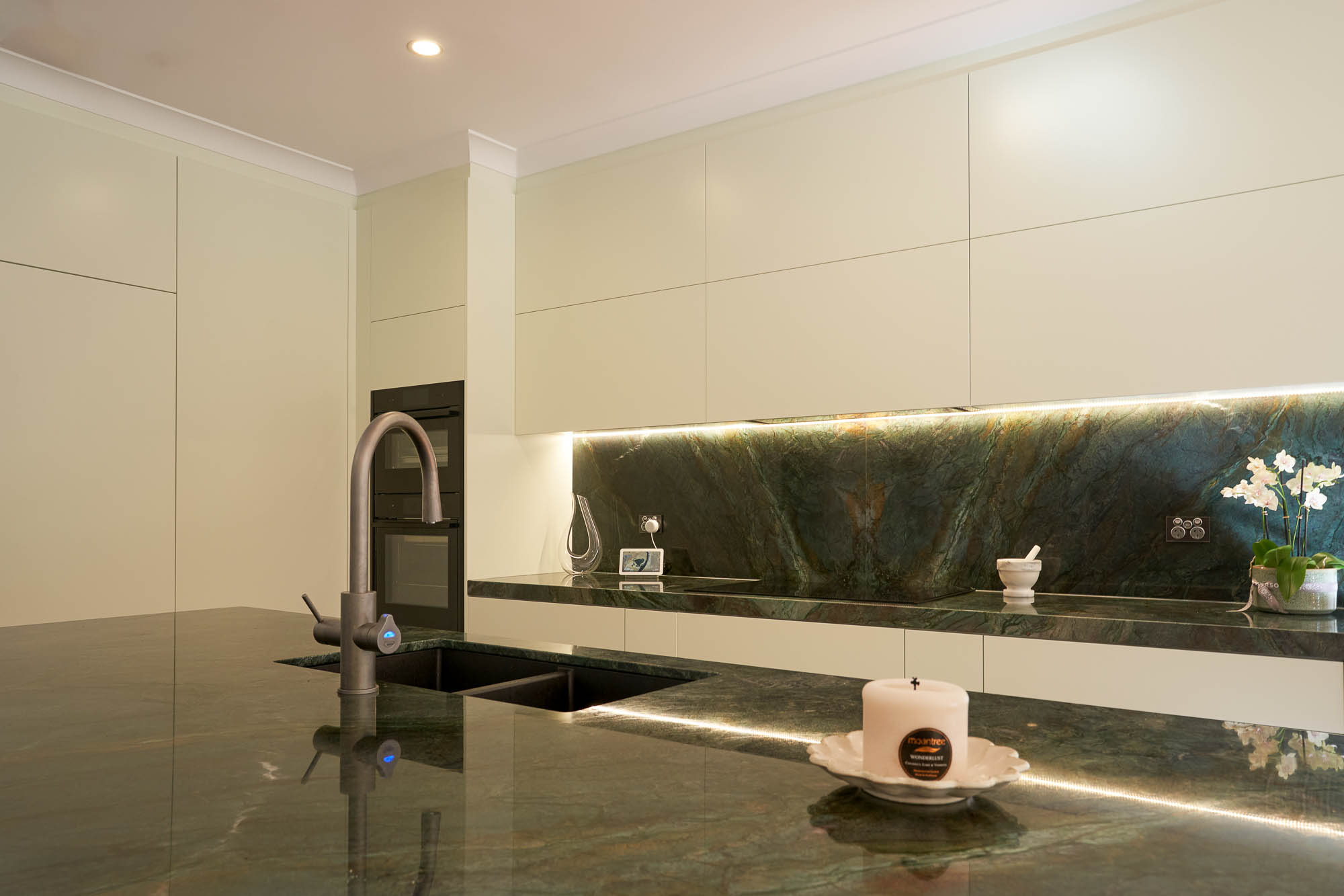 Flat white kitchen island with green stone and integrated sink by Renolux