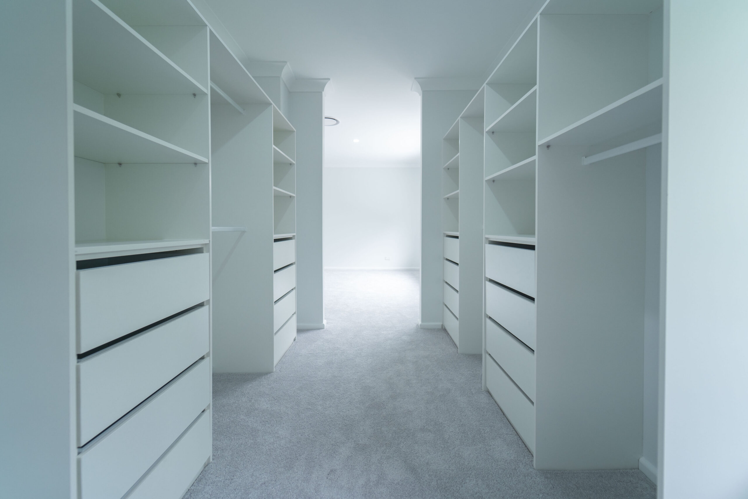 Walk-in wardrobe with white drawers and custom storage