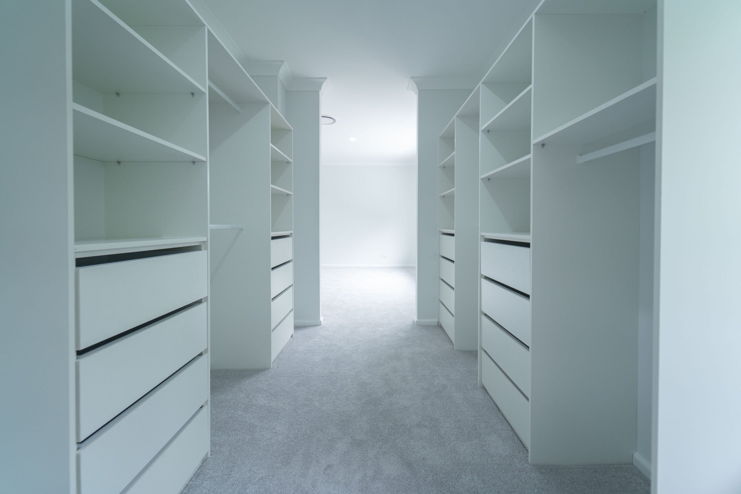 Walk-in wardrobe with white drawers and custom storage